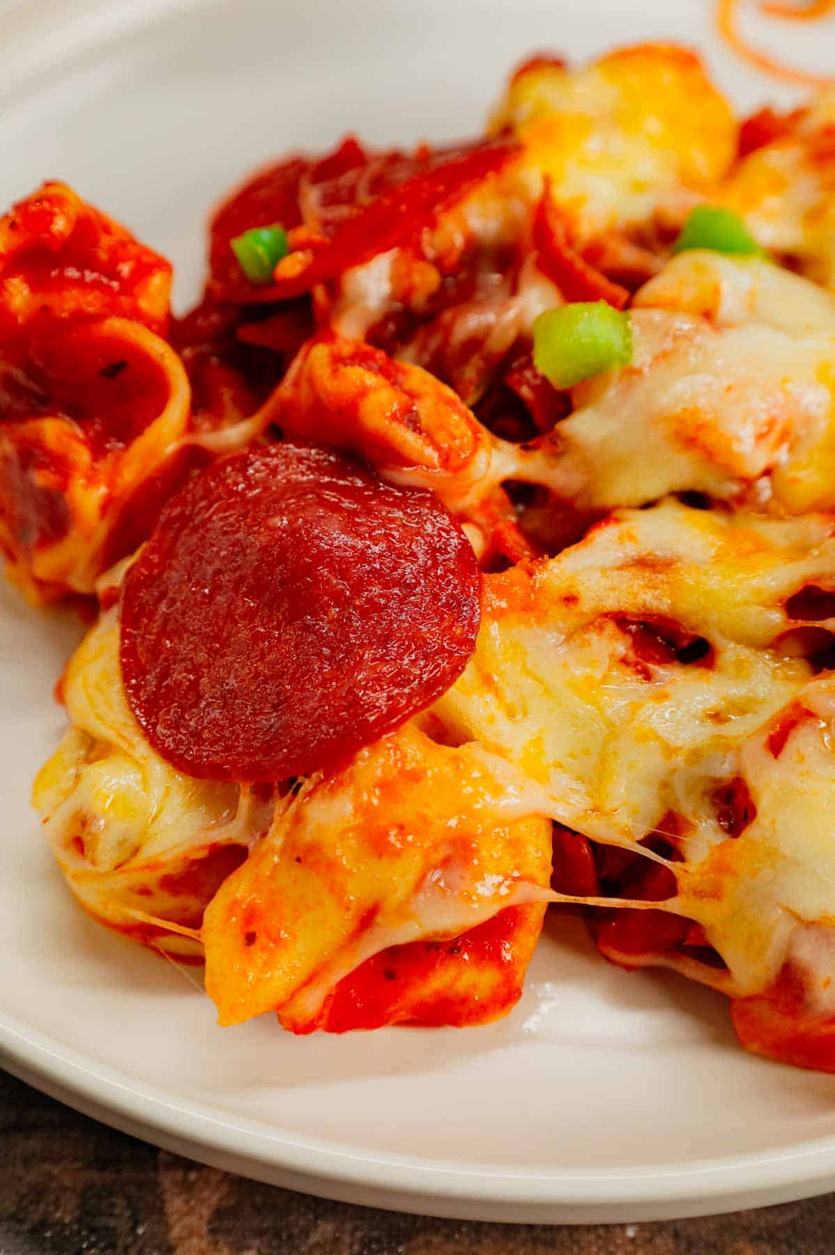 Pizza Tortellini is a hearty pasta dish loaded with Italian sausage meat, cheese tortellini, diced onions, green peppers, pepperoni, pizza sauce, pasta sauce and mozzarella cheese.