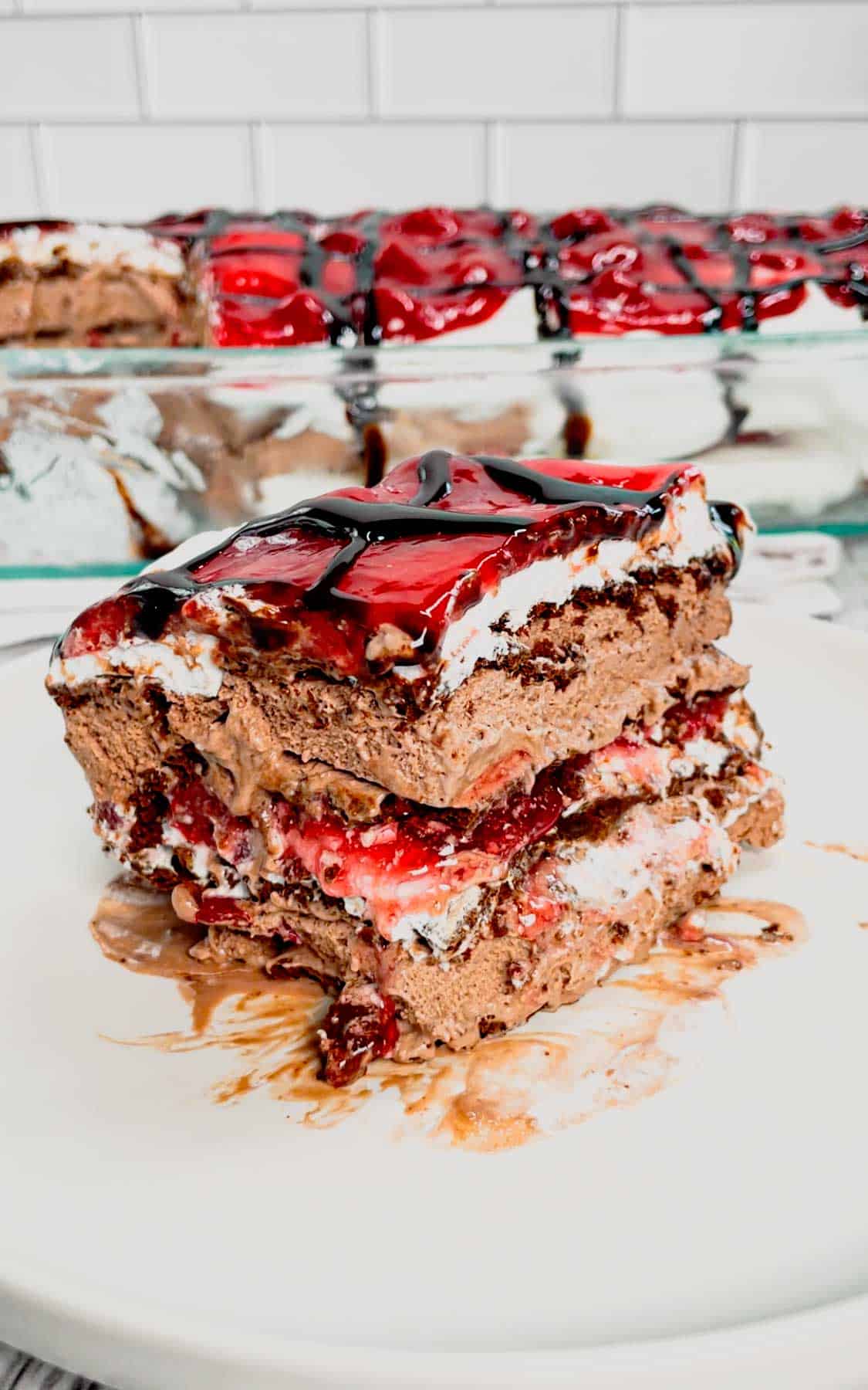 Black Forest Ice Cream Sandwich Cake is an easy 4 ingredient no bake dessert recipe made with chocolate ice cream sandwiches, whipped topping, cherry pie filling and chocolate sauce.