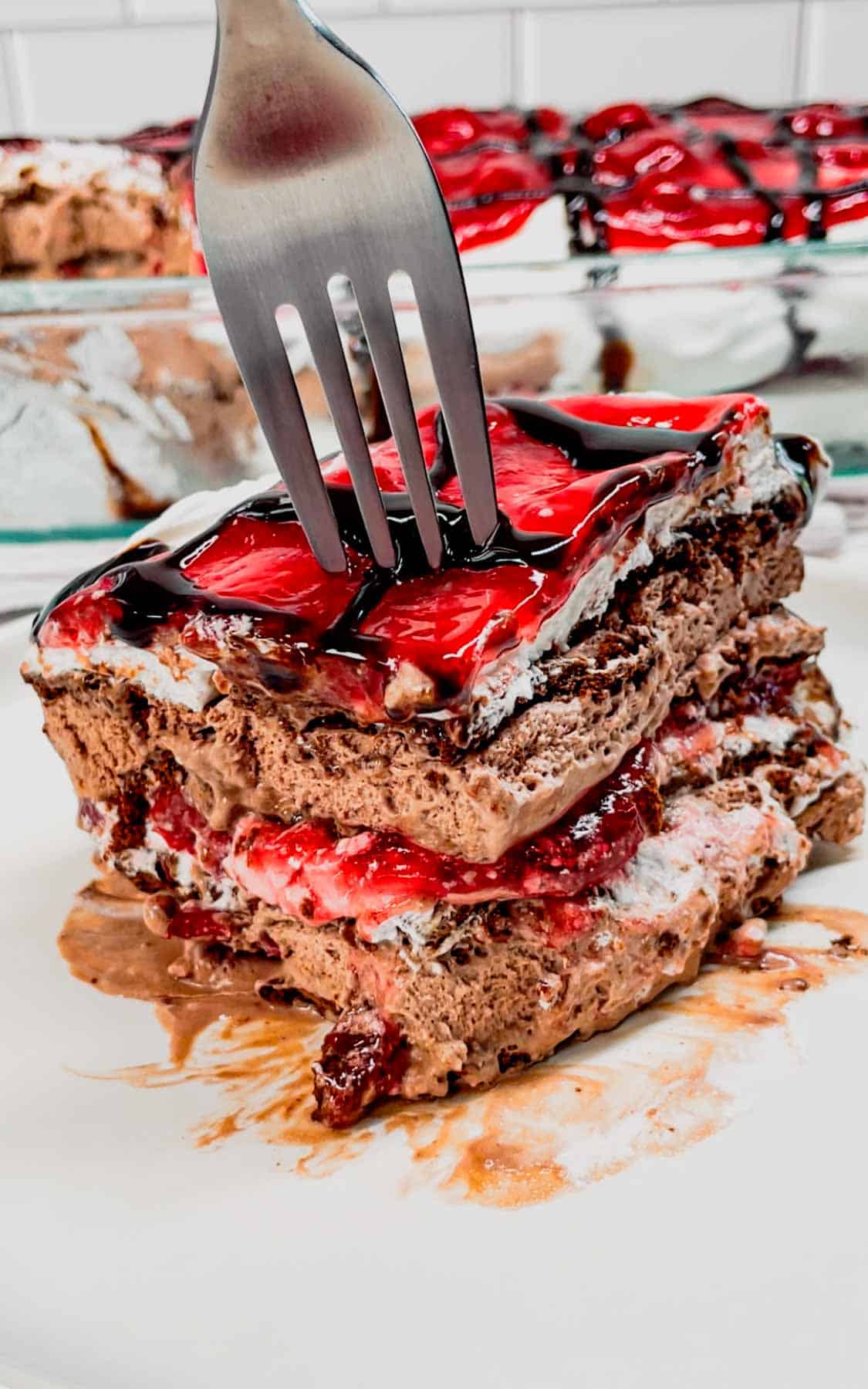 Black Forest Ice Cream Sandwich Cake is an easy 4 ingredient no bake dessert recipe made with chocolate ice cream sandwiches, whipped topping, cherry pie filling and chocolate sauce.