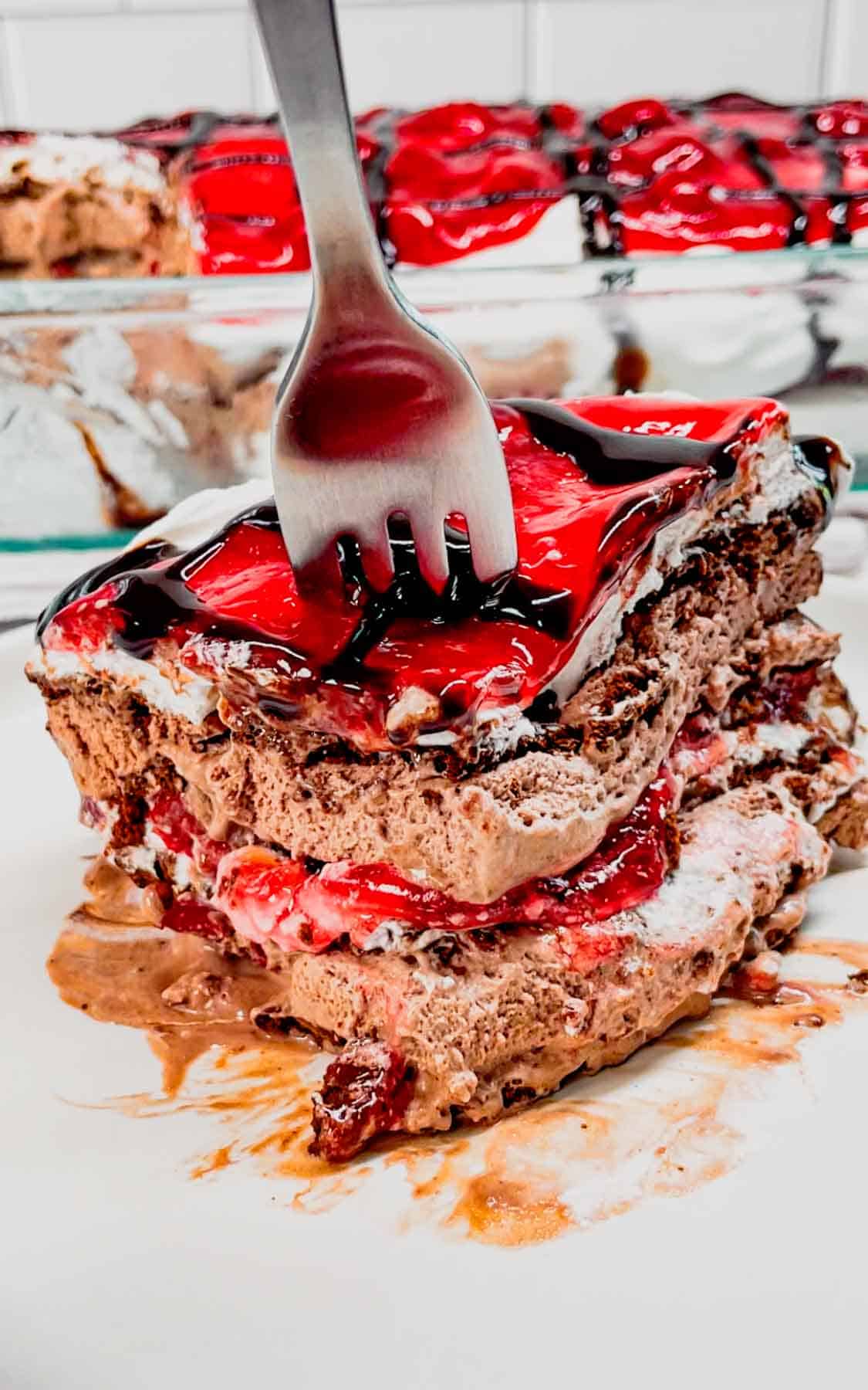 Black Forest Ice Cream Sandwich Cake is an easy 4 ingredient no bake dessert recipe made with chocolate ice cream sandwiches, whipped topping, cherry pie filling and chocolate sauce.