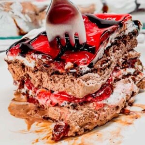 Black Forest Ice Cream Sandwich Cake is an easy 4 ingredient no bake dessert recipe made with chocolate ice cream sandwiches, whipped topping, cherry pie filling and chocolate sauce.