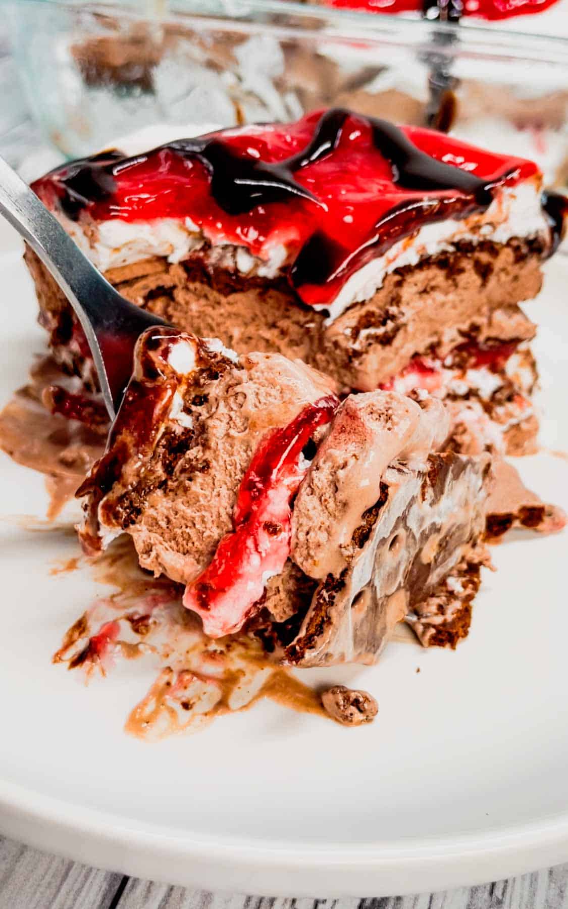 Black Forest Ice Cream Sandwich Cake is an easy 4 ingredient no bake dessert recipe made with chocolate ice cream sandwiches, whipped topping, cherry pie filling and chocolate sauce.