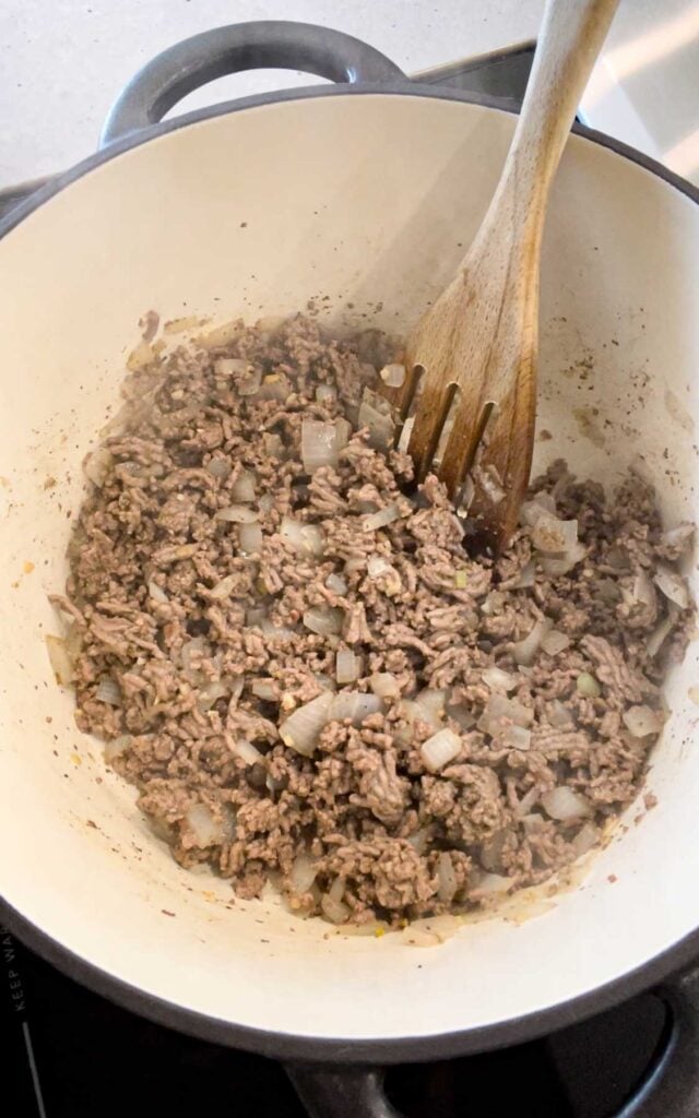 cooked ground beef and diced onions in a pot