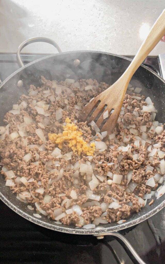 chopped garlic added to skillet with cooked ground beef and diced onions