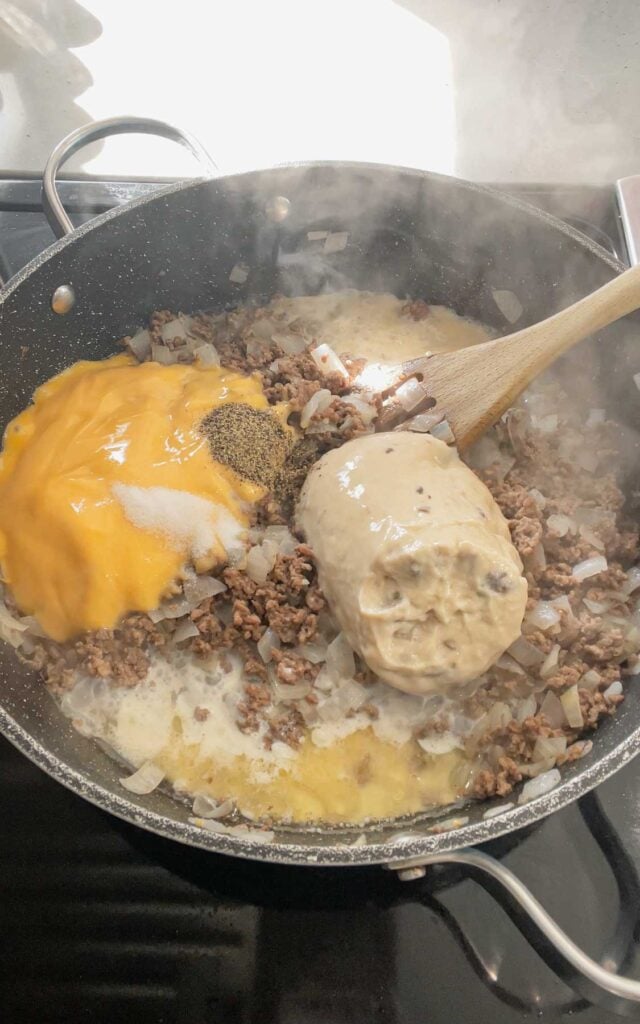 salt, pepper, cheddar soup, cream of mushroom soup and milk added to skillet with cooked ground beef