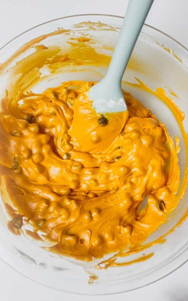 chocolate chips stirred into orange brownie batter in a mixing bowl