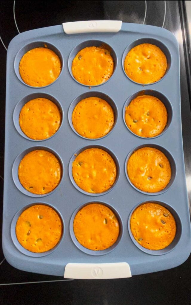 orange coloured brownies in a muffin tin