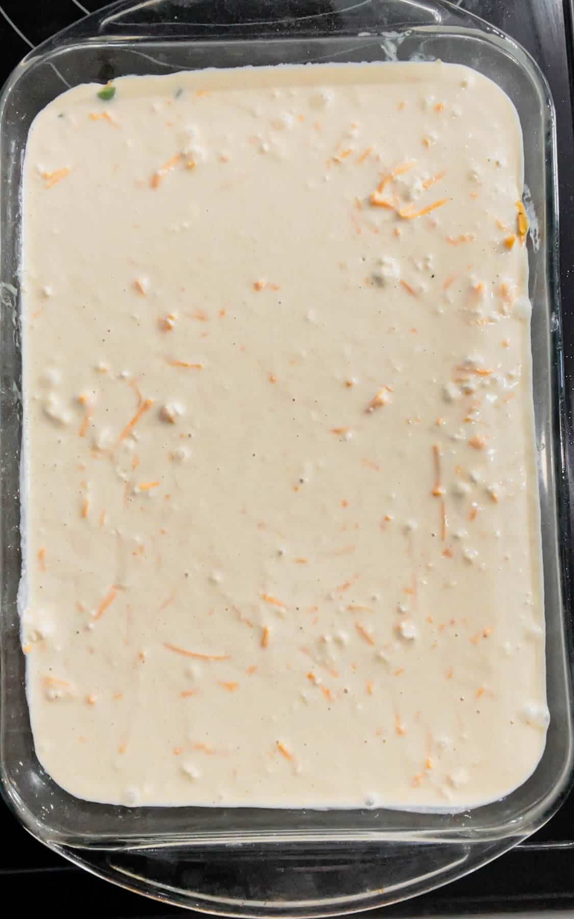 cheddar bay biscuit batter poured over green bean mixture in a baking dish