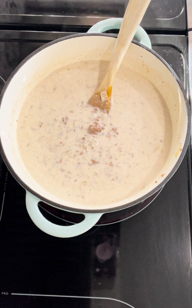 stirring heavy cream into cheeseburger soup