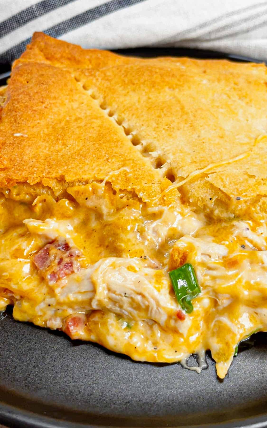 Get ready to fall head over heels for this Crack Chicken Pot Pie with Crescent Rolls—where creamy, cheesy, bacon-packed goodness meets buttery, flaky perfection! This hearty dish is loaded with shredded rotisserie chicken, bacon, ranch seasoning, green onions and cheddar cheese all in a creamy sauce and baked between two layers of Pillsbury crescent rolls.
