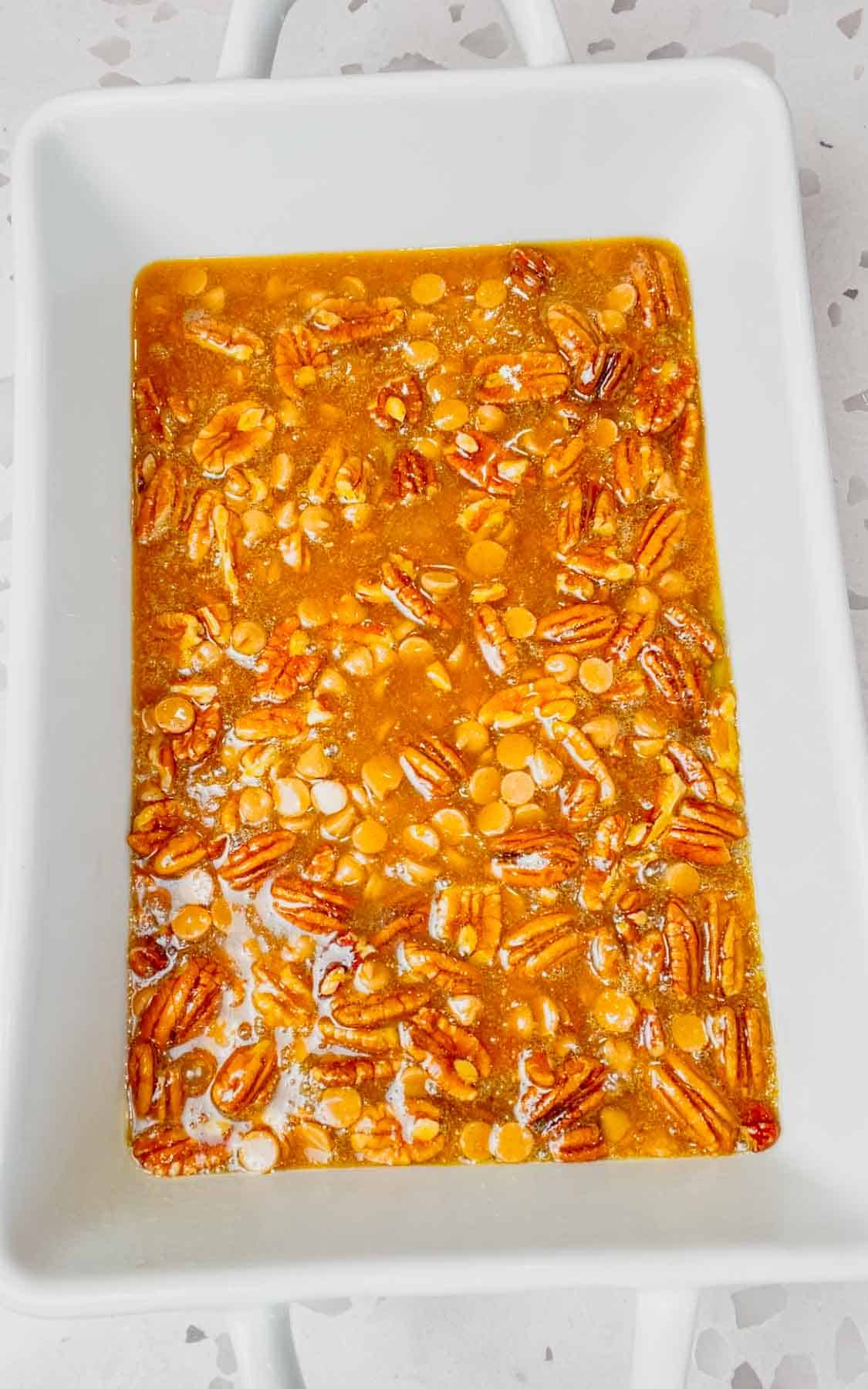 pecan pie filling mixture in the bottom of a 9 x 13 inch baking dish