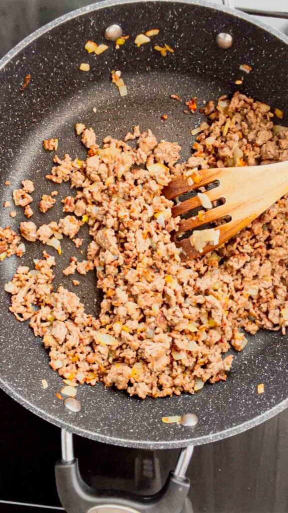 stirring salt and pepper into cooked ground beef in a skillet