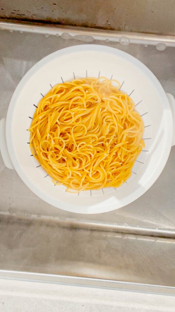 cooked spaghetti noodles in a colander