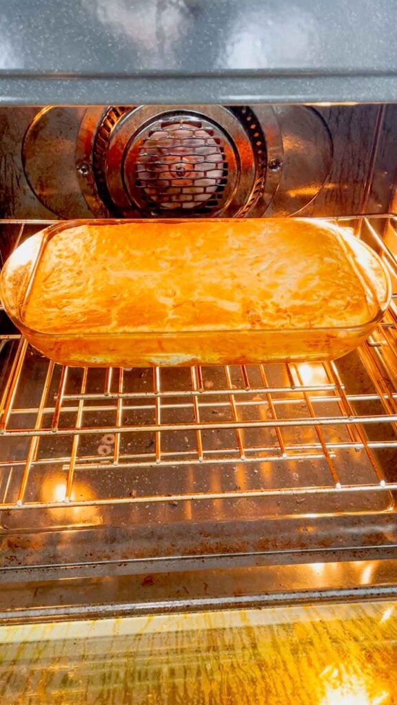 cheddar bay spaghetti casserole in the oven baking until golden brown on top