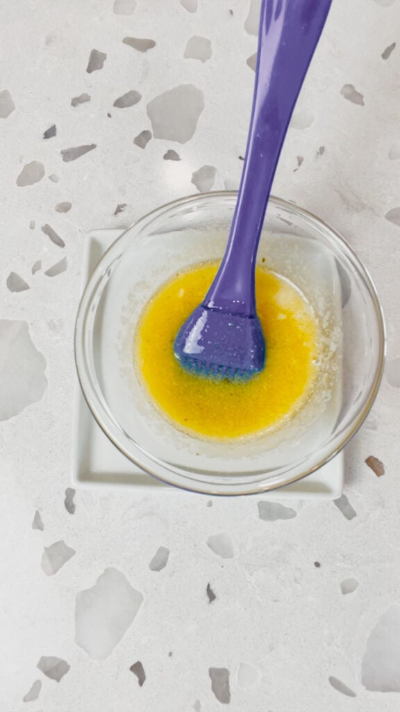 melted butter and seasoning mix stirred together in a small glass bowl