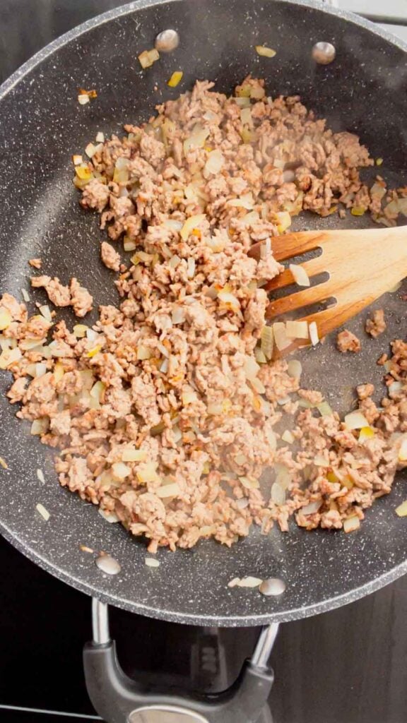 cooked ground beef and diced onions in a skillet