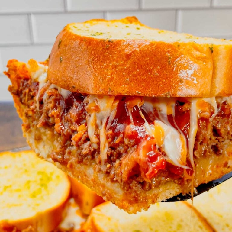 Meatloaf Sandwich casserole is an easy ground beef casserole recipe with all the flavours of the classic sandwich. This hearty casserole starts out with a pizza crust base, followed by a layer of ground beef meatloaf topped with a BBQ ketchup glaze, crispy fried onions, shredded cheese and garlic bread slices.