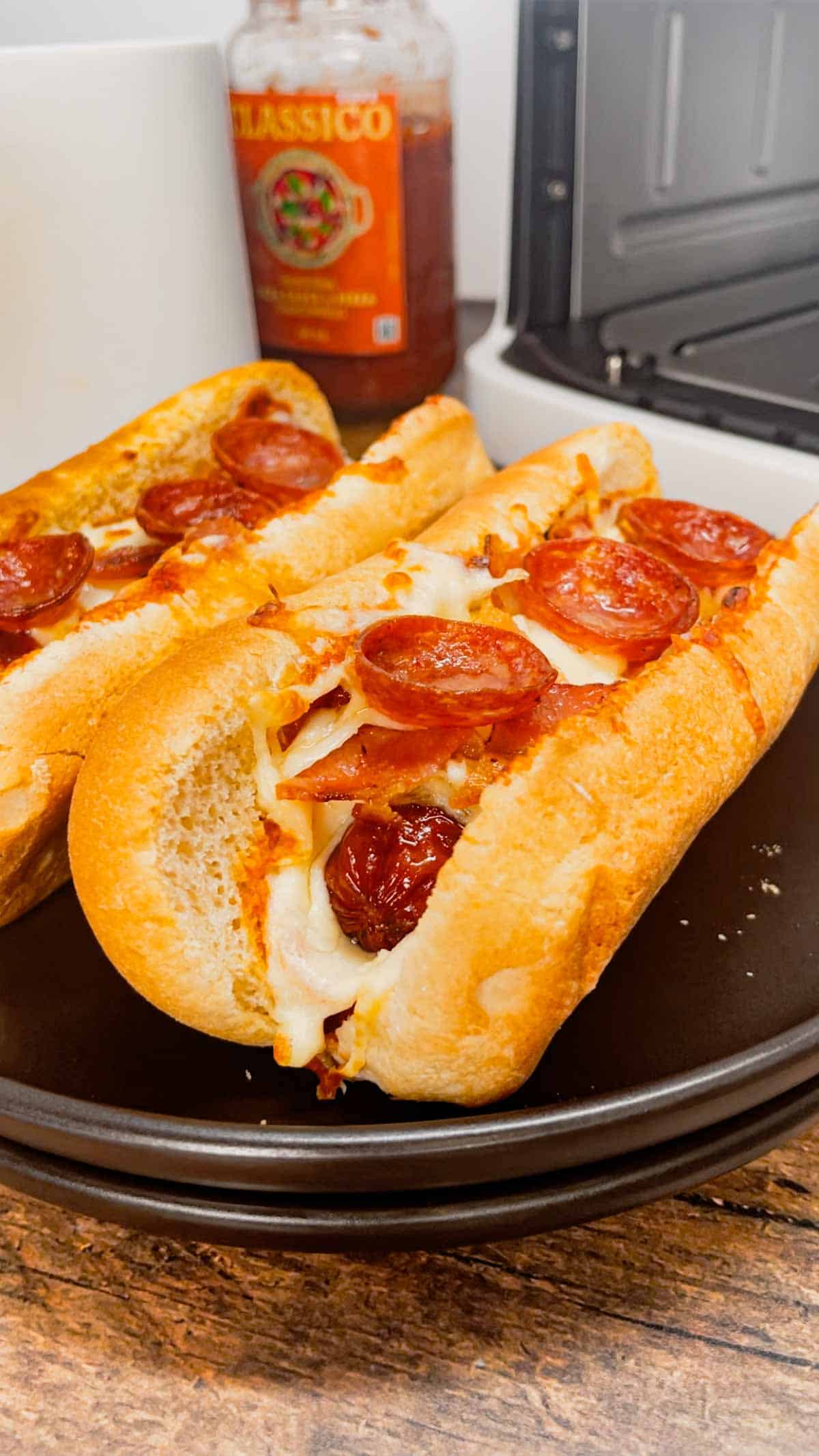 Air Fryer Pizza Dogs are a fun and easy recipe perfect for lunch or a quick weeknight dinner. These tasty hot dogs are loaded with pizza sauce, mozzarella cheese, pepperoni and bacon all air fried to crispy perfection.
