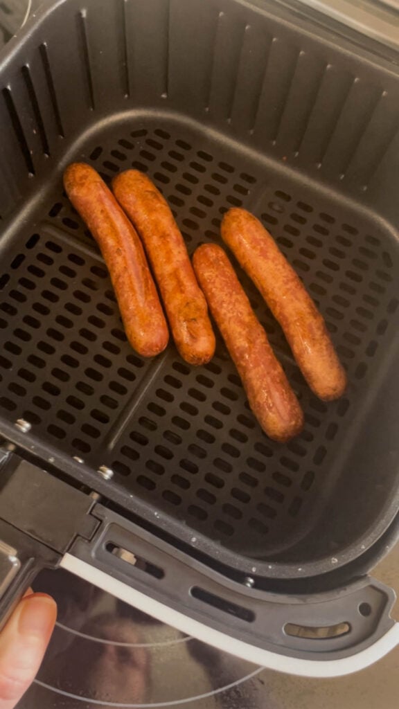 wieners in an air fryer basket after cooking