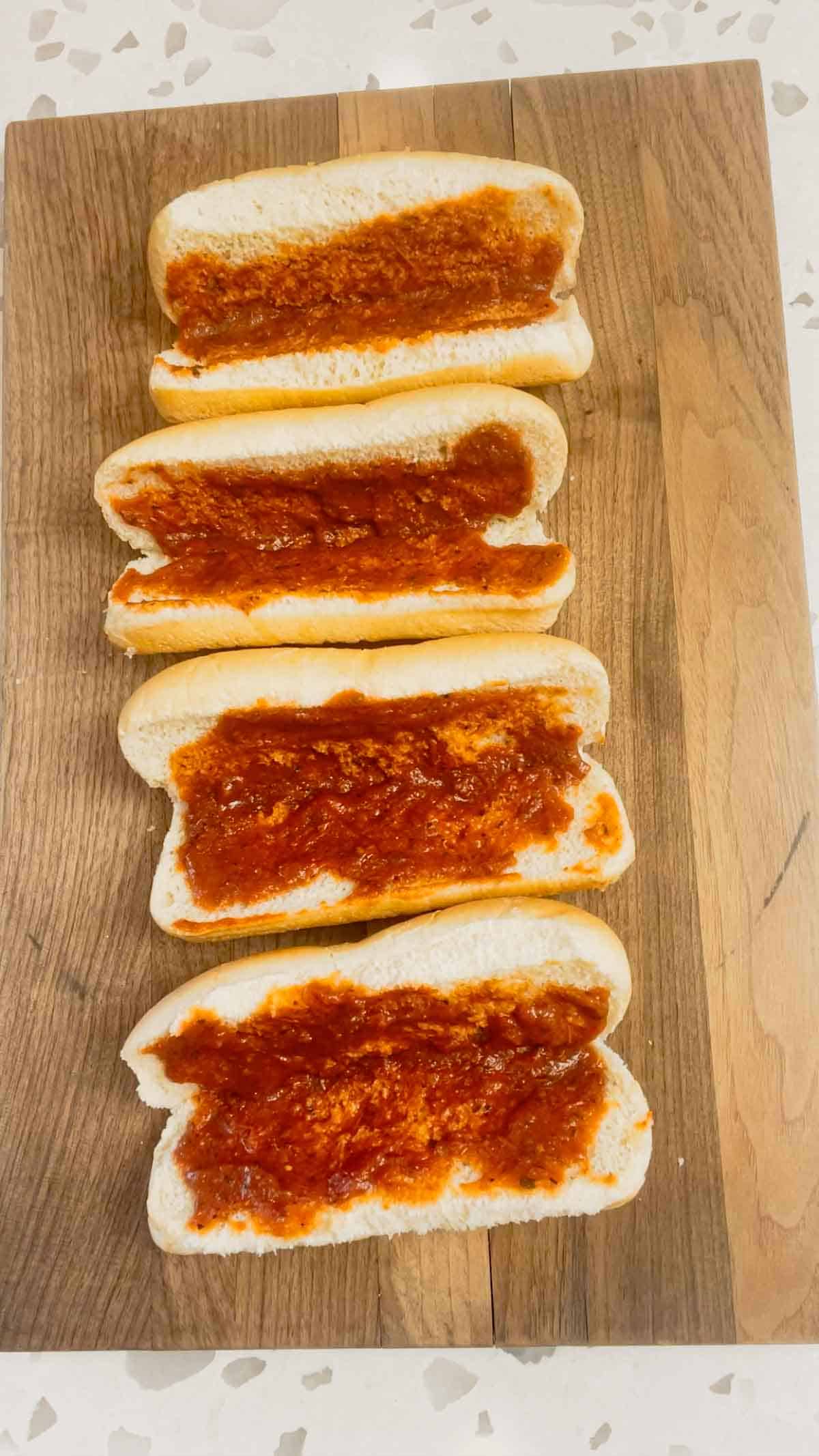hot dog buns spread with pizza sauce
