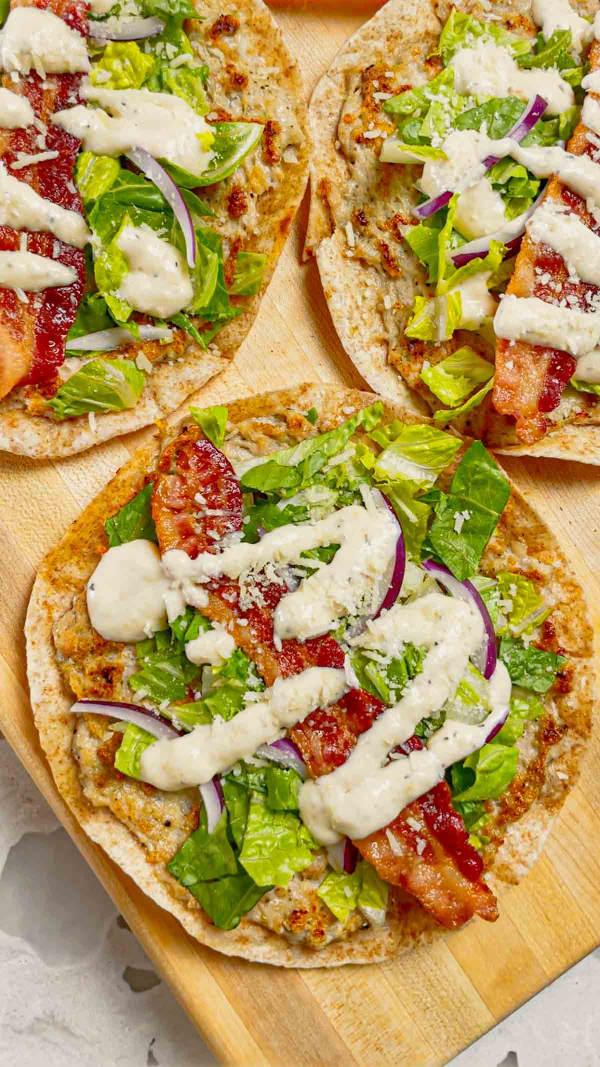 Chicken Caesar Smash Tacos are an dinner recipe made with flour tortillas, ground chicken, chopped romaine, Caesar dressing, bacon and parmesan cheese. These tasty tacos are cooked on a griddle or in a skillet just like classic smash burgers.