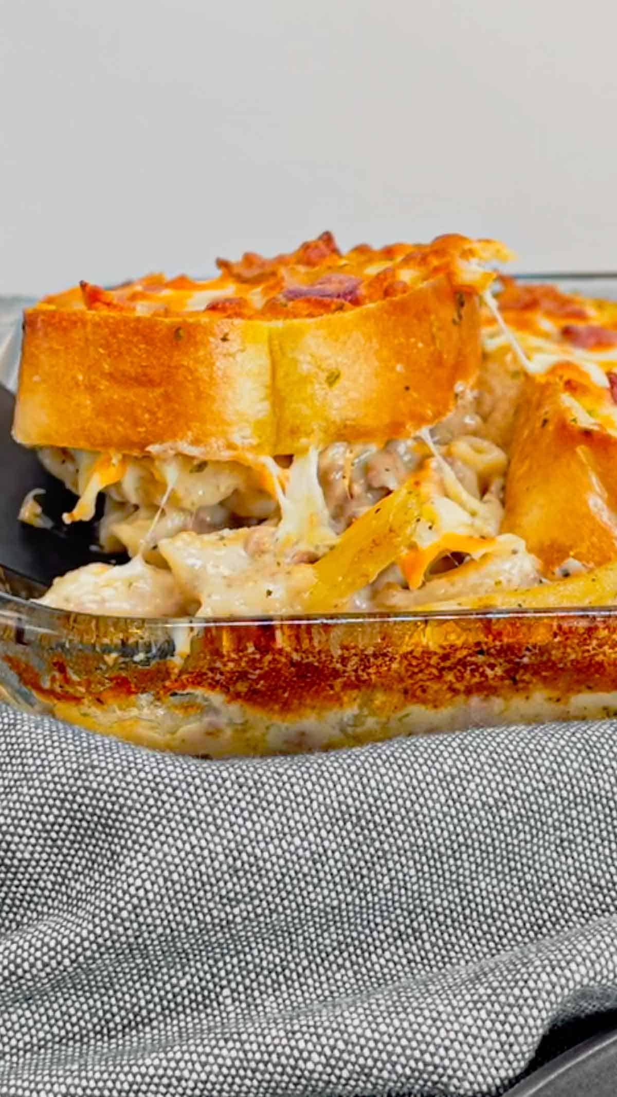Dump and Bake Ground Beef Alfredo is an easy one pan dinner recipe perfect for weeknights. This creamy pasta recipe is made with store bought alfredo sauce, chicken broth, mini penne noodles, cream of bacon soup, ground beef, mozzarella and cheddar cheese, Texas toast garlic bread and bacon.