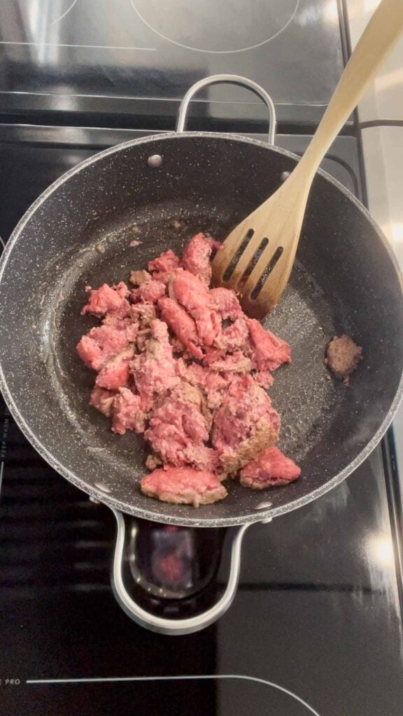 ground beef being broken apart in a skillet