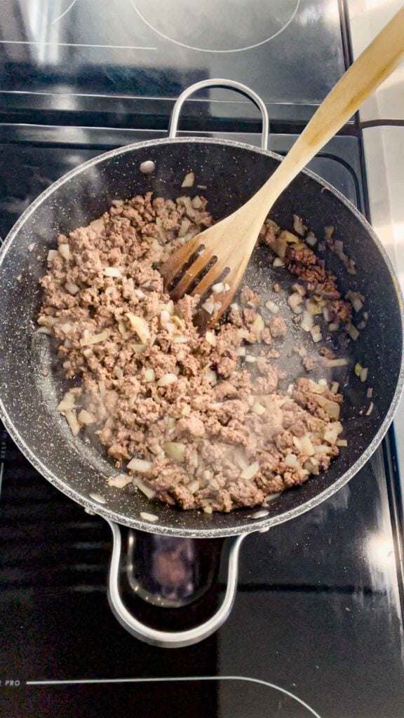 cooked diced onions and ground beef in a skillet