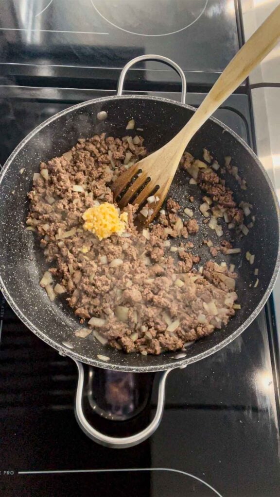 chopped garlic added to skillet with cooked ground beef