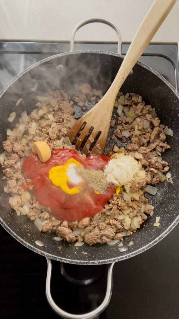 ketchup, mustard, onion powder, salt, pepper and Worcestershire sauce added to skillet with cooked ground beef
