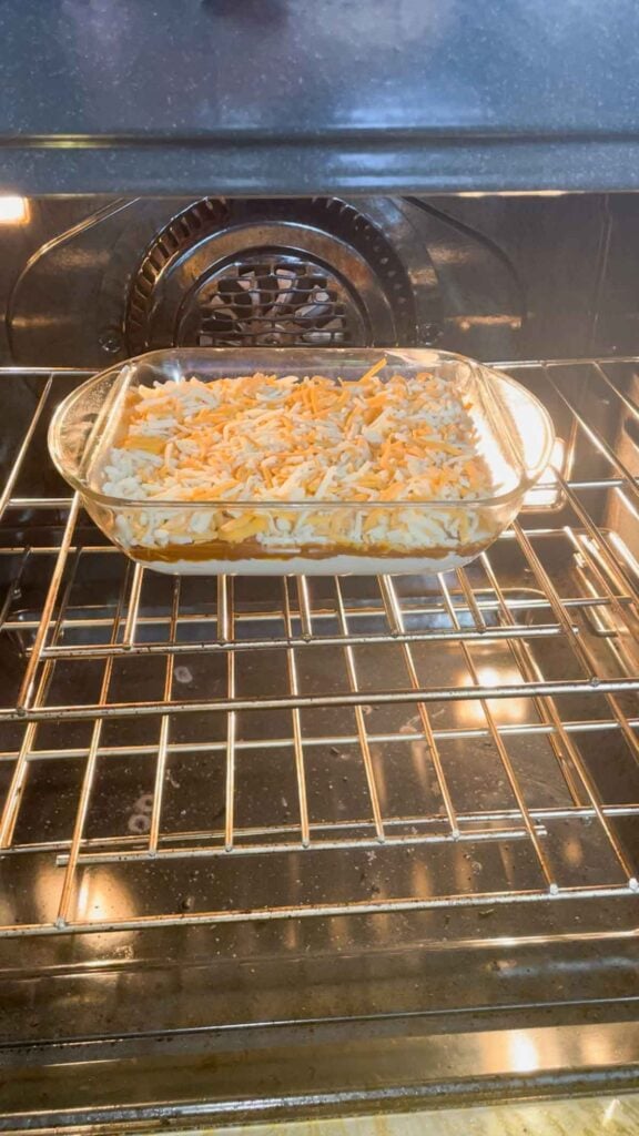 cream cheese chilli dip in a glass baking dish in the oven