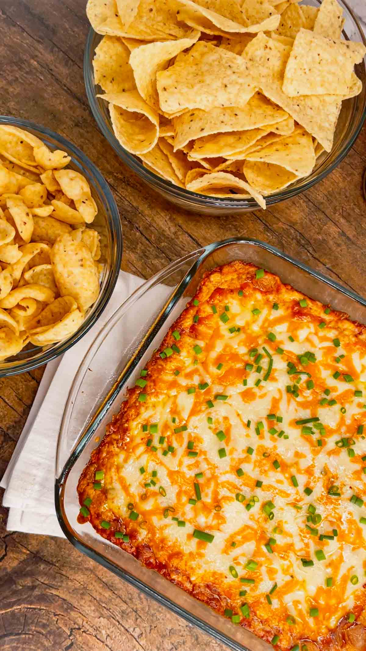 Cream Cheese Chili Dip is a simple and delicious hot party dip recipe perfect for serving with nacho chips, toasted baguette slices and crackers. This quick and easy dip recipe uses sour cream, cream cheese, ranch dressing mix, canned chili, shredded nacho cheese and chopped chives.