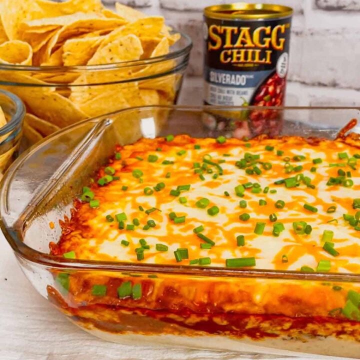 Cream Cheese Chili Dip is a simple and delicious hot party dip recipe perfect for serving with nacho chips, toasted baguette slices and crackers. This quick and easy dip recipe uses sour cream, cream cheese, ranch dressing mix, canned chili, shredded nacho cheese and chopped chives.