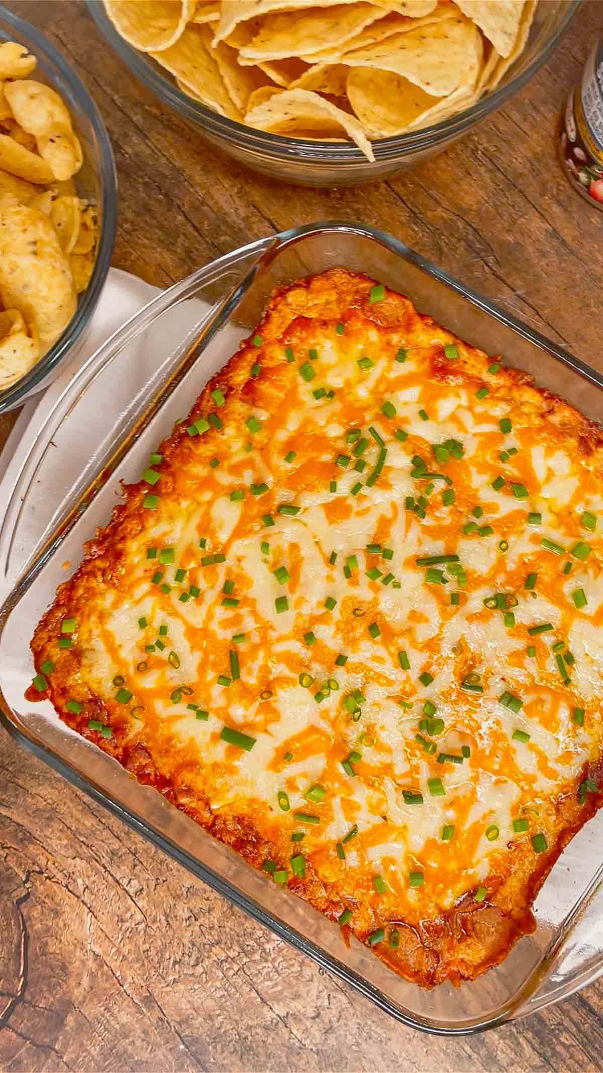 Cream Cheese Chili Dip is a simple and delicious hot party dip recipe perfect for serving with nacho chips, toasted baguette slices and crackers. This quick and easy dip recipe uses sour cream, cream cheese, ranch dressing mix, canned chili, shredded nacho cheese and chopped chives.