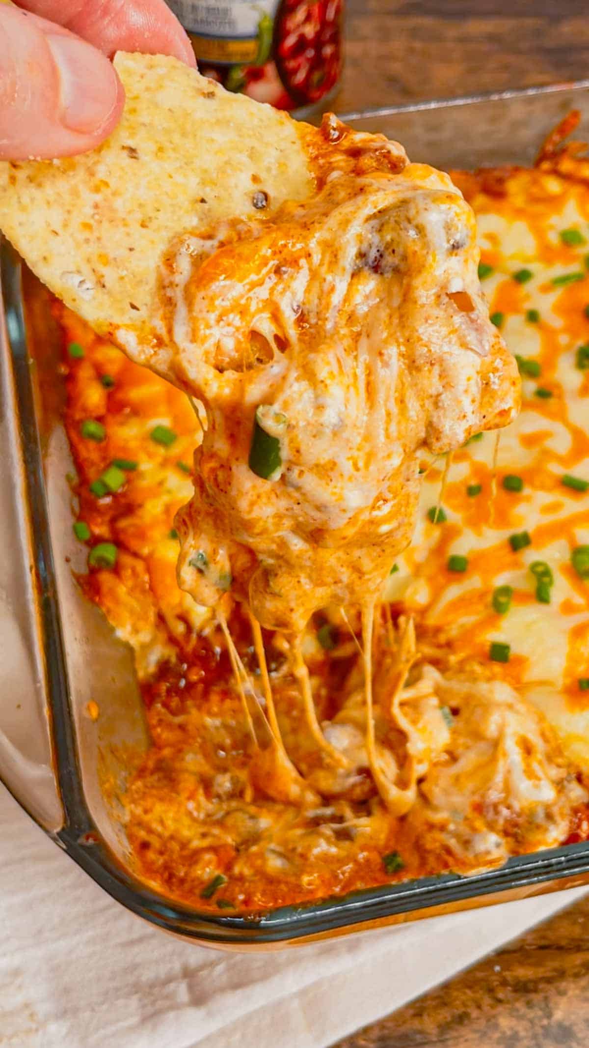 Cream Cheese Chili Dip is a simple and delicious hot party dip recipe perfect for serving with nacho chips, toasted baguette slices and crackers. This quick and easy dip recipe uses sour cream, cream cheese, ranch dressing mix, canned chili, shredded nacho cheese and chopped chives.