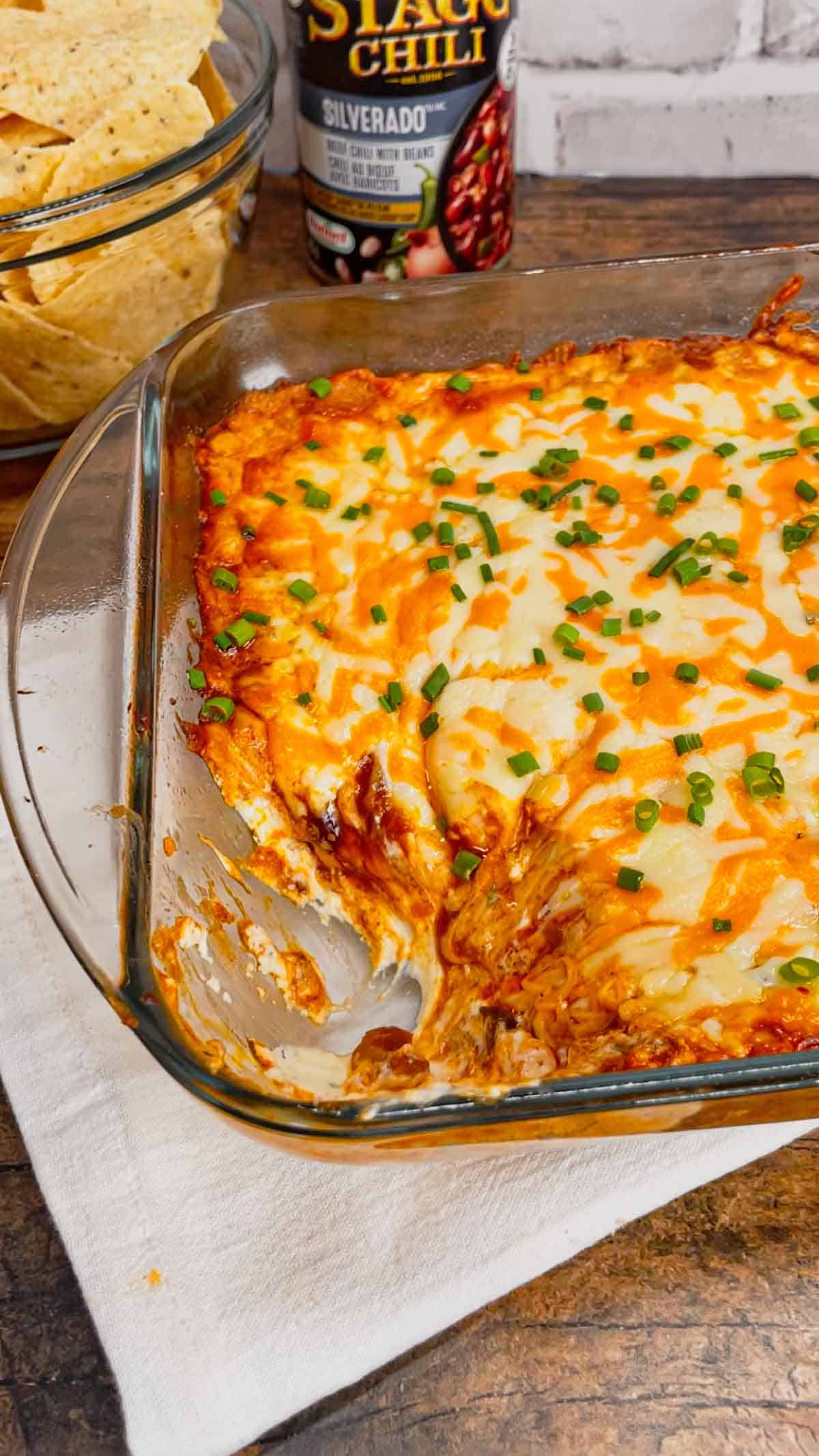Cream Cheese Chili Dip is a simple and delicious hot party dip recipe perfect for serving with nacho chips, toasted baguette slices and crackers. This quick and easy dip recipe uses sour cream, cream cheese, ranch dressing mix, canned chili, shredded nacho cheese and chopped chives.