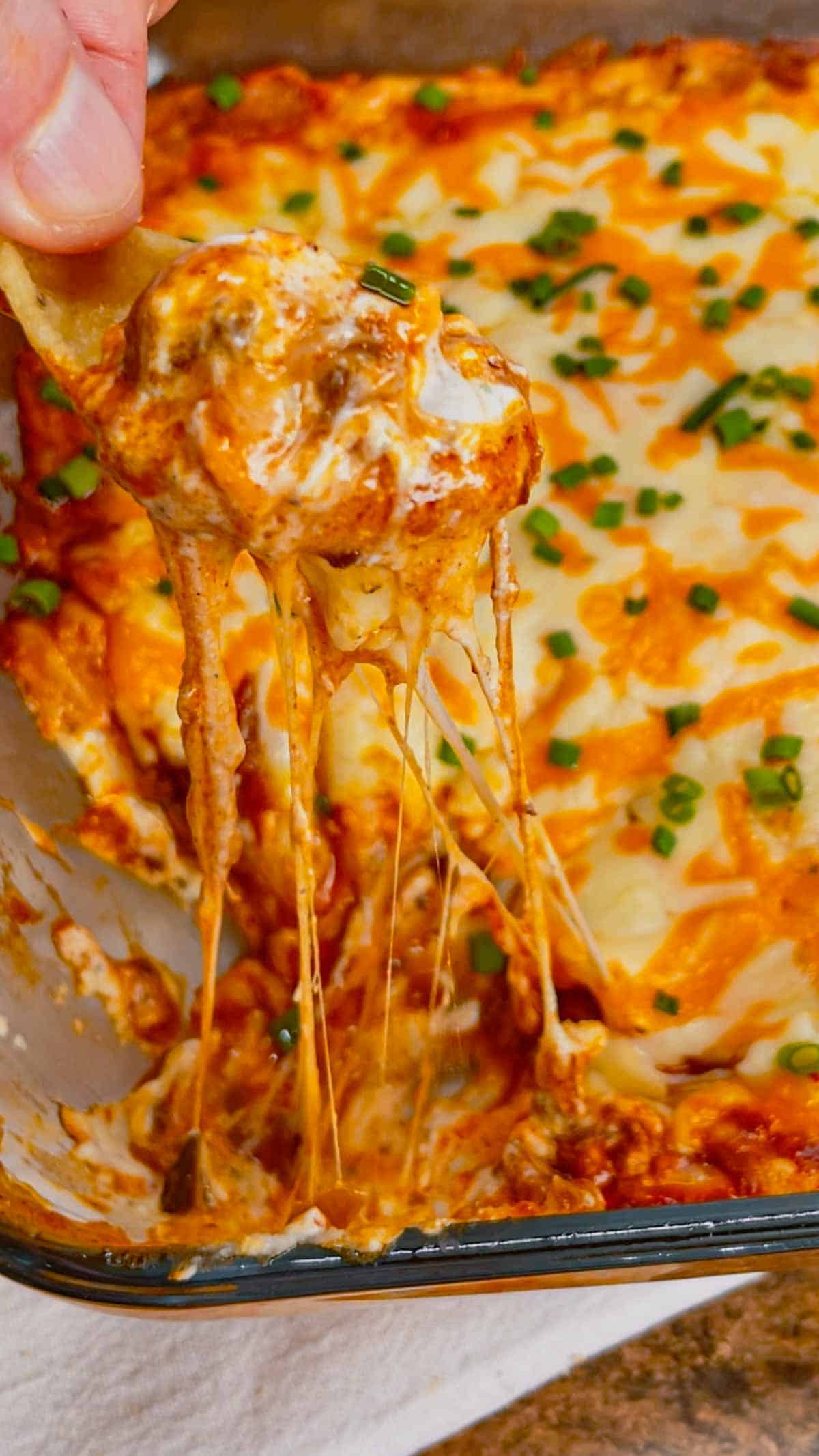 Cream Cheese Chili Dip is a simple and delicious hot party dip recipe perfect for serving with nacho chips, toasted baguette slices and crackers. This quick and easy dip recipe uses sour cream, cream cheese, ranch dressing mix, canned chili, shredded nacho cheese and chopped chives.