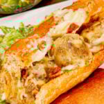 Garlic Bread Alfredo Meatballs are an easy family friendly dinner recipe perfect for busy weeknights. These sub buns are slathered with garlic spread and loaded with meatballs in creamy alfredo sauce, shredded mozzarella cheese and crumbled bacon before being baked to perfection.