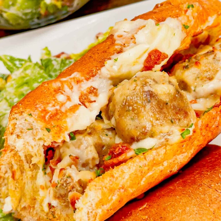 Garlic Bread Alfredo Meatballs are an easy family friendly dinner recipe perfect for busy weeknights. These sub buns are slathered with garlic spread and loaded with meatballs in creamy alfredo sauce, shredded mozzarella cheese and crumbled bacon before being baked to perfection.