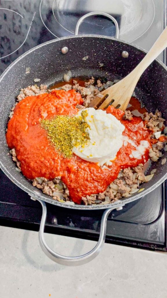 Italian seasoning and ricotta added to skillet with marinara sauce and cooked ground beef