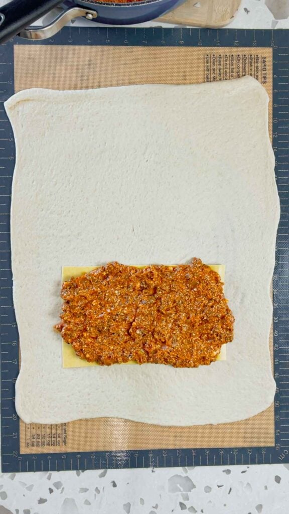 meat sauce on top of lasagna sheet on top of pizza dough