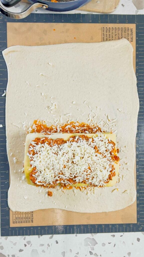 layered lasagna on top of pizza dough
