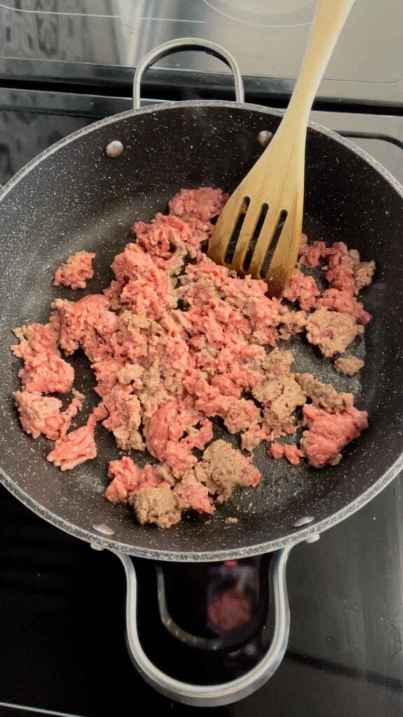 ground beef being broken apart in a skillet