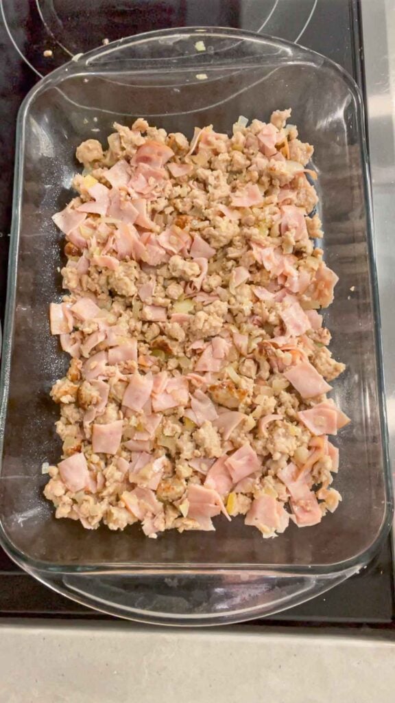 cooked sausage meat and ham in a baking dish