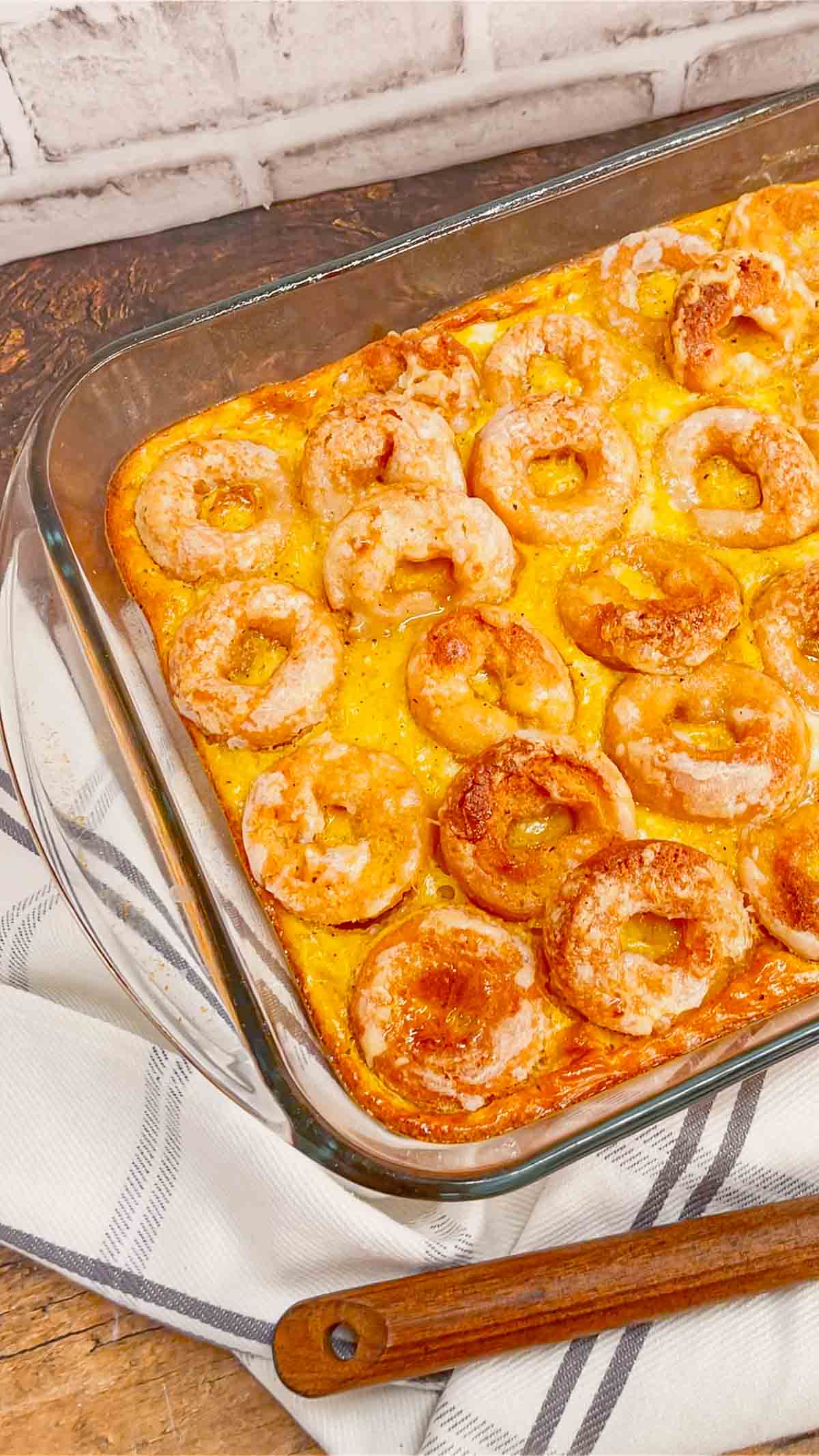 Mini Donut Breakfast Casserole is a fun and delicious brunch dish perfect for holidays and special occasions. This dish is loaded with sausage, ham, eggs, mozzarella cheese, store bought mini donuts and maple syrup.