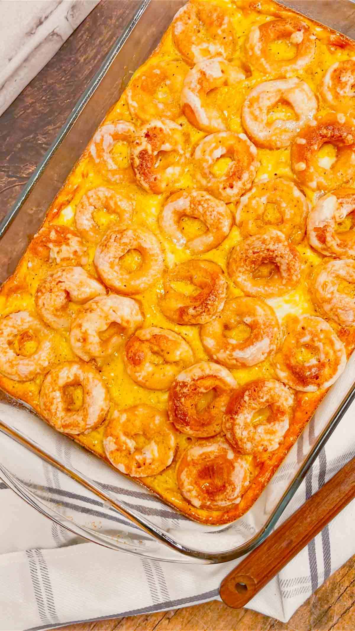 Mini Donut Breakfast Casserole is a fun and delicious brunch dish perfect for holidays and special occasions. This dish is loaded with sausage, ham, eggs, mozzarella cheese, store bought mini donuts and maple syrup.