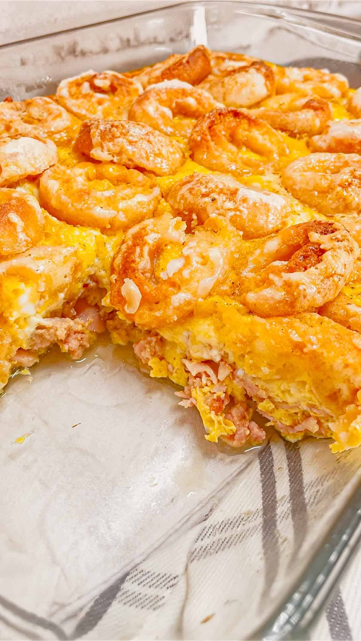Mini Donut Breakfast Casserole is a fun and delicious brunch dish perfect for holidays and special occasions. This dish is loaded with sausage, ham, eggs, mozzarella cheese, store bought mini donuts and maple syrup.