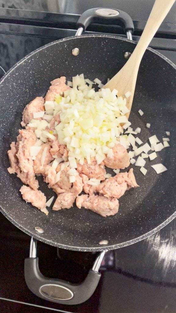 diced onions added to skillet with sausage meat