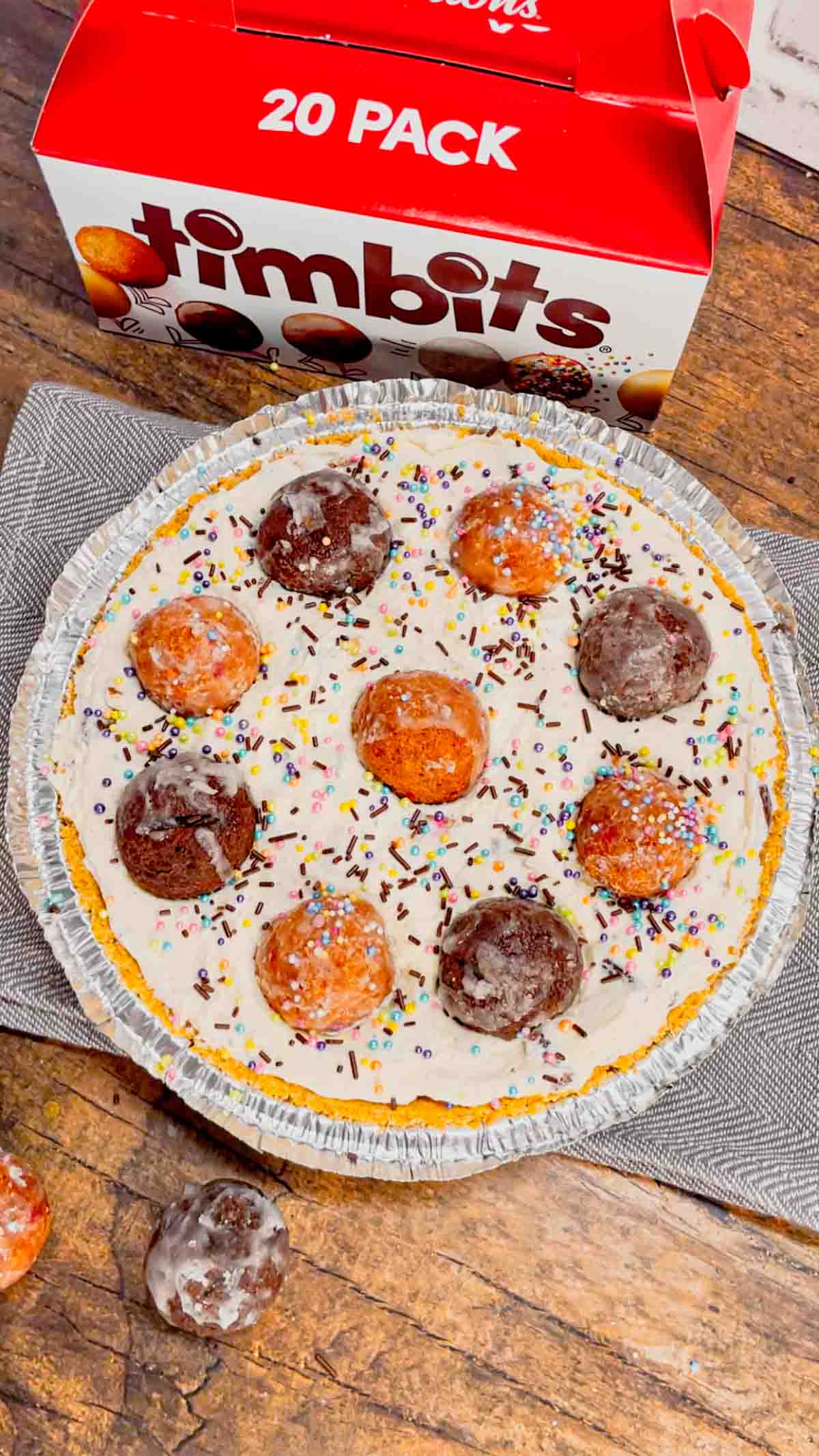 No Bake Timbit Cheesecake is a rich and creamy dessert recipe loaded with tasty donut holes. This cheesecake is made with a store bought graham pie crust and the cream cheese filling is loaded Tim Horton's chocolate and birthday cake flavoured Timbits.