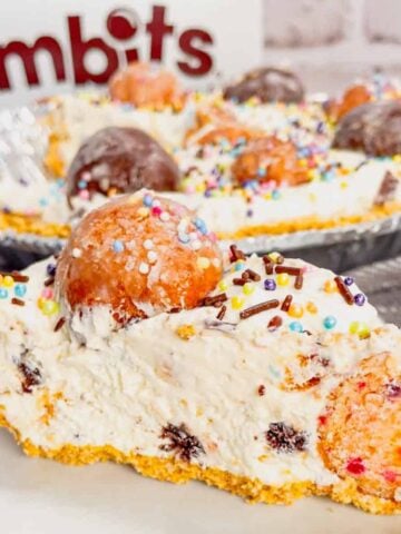 No Bake Timbit Cheesecake is a rich and creamy dessert recipe loaded with tasty donut holes. This cheesecake is made with a store bought graham pie crust and the cream cheese filling is loaded Tim Horton's chocolate and birthday cake flavoured Timbits.